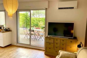 ein Wohnzimmer mit einem TV auf der Kommode in der Unterkunft Le Petit Jaune - Studio - Terrasse & Plage Pointe Rouge in Marseille