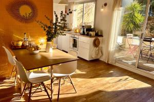 eine Küche mit Holztisch und Stühlen und ein Esszimmer in der Unterkunft Le Petit Jaune - Studio - Terrasse & Plage Pointe Rouge in Marseille