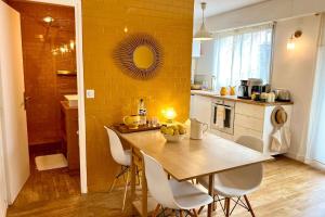 eine Küche mit Tisch und Stühlen und einer gelben Wand in der Unterkunft Le Petit Jaune - Studio - Terrasse & Plage Pointe Rouge in Marseille + 21 Fotos