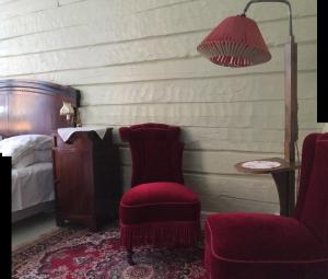 een slaapkamer met een stoel, een lamp en een bed bij Gjestehuset IBSEN in Grimstad