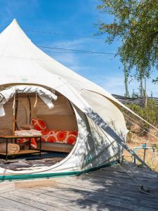 El RosarioLa Colmena Glamping Zangano的甲板上的帐篷,配有一张床