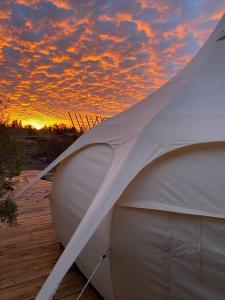 El RosarioLa Colmena Glamping Reina的海滩上的帐篷,背面是日落