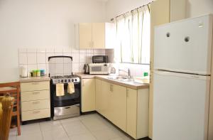 a kitchen with a stove and a white refrigerator at Rachel's Apartments in Paramaribo