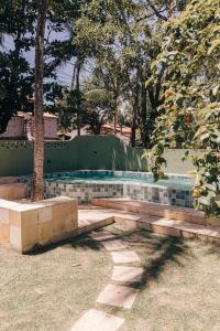 Un parque con dos bancos frente a una piscina. en Pousada Maracaju, en Porto de Galinhas