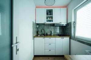 a kitchen with white cabinets and a sink at Urban Escape Studio in Ploieşti