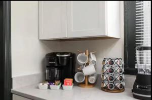 a kitchen counter with utensils and a coffee maker at 3BR Downtown-Old Salem Oasis in Winston-Salem