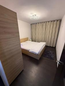 ein kleines Schlafzimmer mit einem Bett und einer Schiebetür in der Unterkunft Sweet home lux RF in Buzău