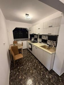 eine Küche mit einem Tisch und einem Waschbecken sowie einem Tisch und Stühlen in der Unterkunft Sweet home lux RF in Buzău