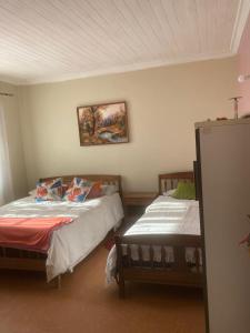 ein Schlafzimmer mit zwei Betten und einem Bild an der Wand in der Unterkunft Habitaciones en Casa de la Playa! in Quintero