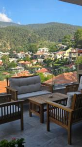 a patio with two benches and a table and a view at Ephrosinis Cottage in Pedoulas