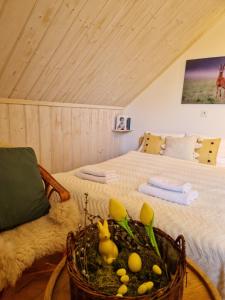 Un dormitorio con una cama y una cesta con patos dentro. en Górskie Siedlisko - 3 Chaty, en Rycerka Górna