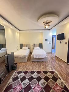 een slaapkamer met twee bedden en een flatscreen-tv bij Middle East pyramids veiw &spa in Caïro