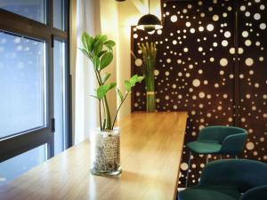 a vase with a plant sitting on top of a table at Mercure Perpignan Centre in Perpignan