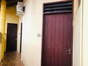 a red garage door in a hallway with two doors at Pousada Doromari in Taíba +12 photos