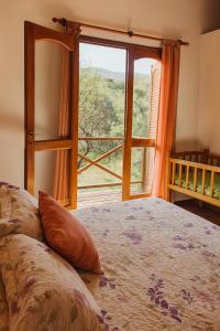 ein Schlafzimmer mit einem Bett und einem großen Fenster in der Unterkunft Complejo Pasos Malos in Merlo