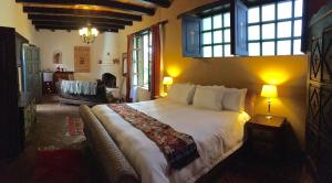 a bedroom with a large bed and a living room at Guayaba Inn Boutique Hotel in San Cristóbal de Las Casas