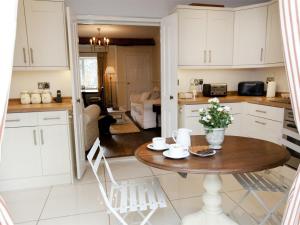 a kitchen with white cabinets and a wooden table at 2 Bed in Richmond oc-g0116 in Hutton Magna +6 photos