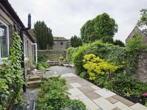 einen Garten mit einem steinernen Gehweg vor einem Haus in der Unterkunft 2 Bed in Richmond oc-g0116 in Hutton Magna