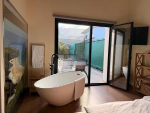 een groot wit bad in een kamer met balkon bij Las Mareas de Llanes in Andrín +107 foto's