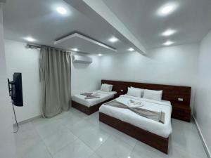 een kamer met twee bedden en een televisie bij Prince pyramids Historical in Caïro