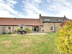 a stone house with a table and chairs in the yard at 3 Bed in Beadnell oc-cn113 in Beadnell