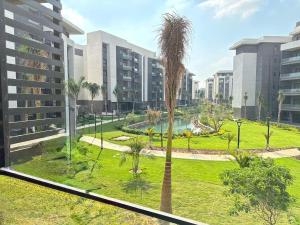 a palm tree in front of a building at loved modern home 2BR in New cairo
