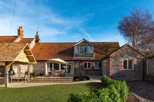 een bakstenen huis met een terras en een dak bij 4 Bed in Blakeney oc-1948 in Blakeney