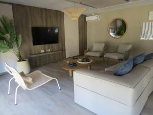 コスタ・デル・エステにあるDepartamento de mar- UF5-La Reserva Almarenaのソファと椅子とテレビのあるリビングルーム
