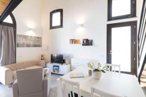 een woonkamer met een witte tafel en stoelen bij Casa Rifa in Serramanna