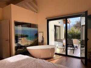 a large bath tub in a bedroom with a balcony at Las Mareas de Llanes in Andrín
