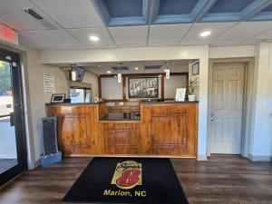 una cucina con armadi in legno e un lavandino in camera di Super 8 by Wyndham Marion NC a Marion