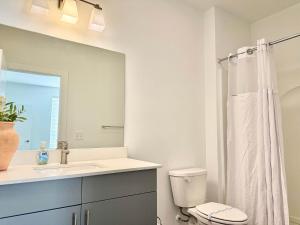 ein Badezimmer mit Waschbecken, Toilette und Spiegel in der Unterkunft Luxury 4Beds 3Baths 2Balcony Penthouse 542Blvd in Atlanta