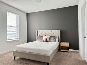 ein Schlafzimmer mit einem Bett mit einer grauen Wand in der Unterkunft Luxury 4Beds 3Baths 2Balcony Penthouse 542Blvd in Atlanta