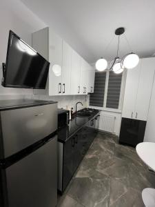 a kitchen with a refrigerator and a tv on top at Ideal House Rent in Petroşani
