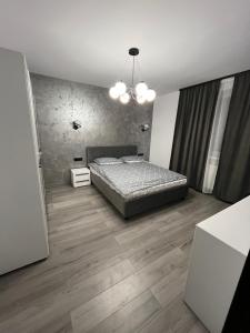 una camera da letto con un letto e un pavimento in legno di Ideal House Rent a Petroşani
