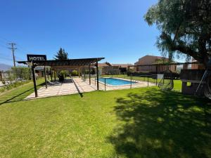 a pavilion with a swimming pool in a yard at Hotel Altos de Tuqui in Ovalle