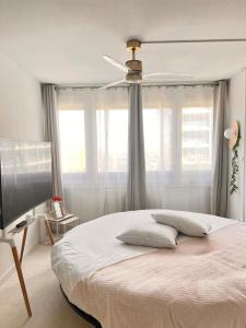 ein Schlafzimmer mit einem Bett mit Deckenventilator in der Unterkunft Suite 2 à 4 personnes lit rond Bergson Stade Zénith in Saint-Étienne