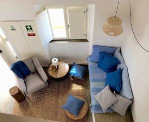 una vista dall'alto di un soggiorno con cuscini blu di Casa Poente - Casas de Seixe a São Teotónio