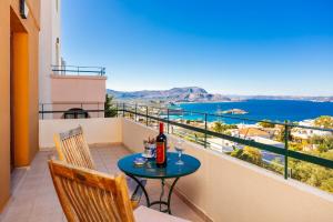 - une table avec une bouteille de vin sur le balcon dans l'établissement Odysseus Villa, à Pláka