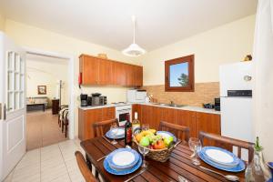 a kitchen with a wooden table with a bowl of fruit on it at Odysseus Villa in Plaka