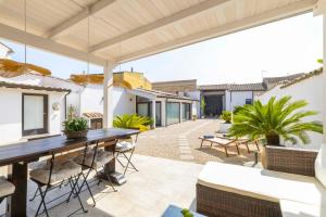 een terras met een houten tafel en stoelen bij Casa Rifa in Serramanna
