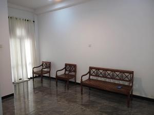 drie houten stoelen in een kamer bij The Grand Villa Malabe in Malabe