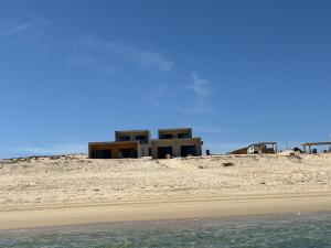 a house sitting on top of a sandy beach at Grand Ocean View Suite with Private Pool in La Paz