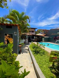 Un complejo con piscina y una casa. en Pousada do Rock, en Arraial d'Ajuda