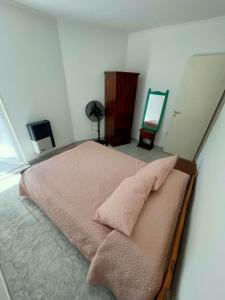 a bedroom with a bed with pink sheets and a mirror at Departamentos Los Manantiales in Villa Gesell