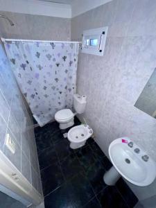 a bathroom with a toilet and a sink at Departamentos Los Manantiales in Villa Gesell +17 photos