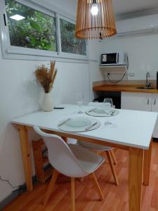 una cucina con tavolo e sedie bianchi e bicchieri da vino di CABAÑA MOAI a Mar del Plata Altre 10 foto