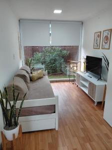 una camera con letto, TV e ampia finestra di CABAÑA MOAI a Mar del Plata