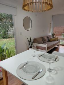 un tavolo bianco con due piatti e bicchieri di CABAÑA MOAI a Mar del Plata