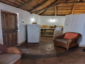 een keuken met een koelkast en stoelen in een kamer bij Out of Africa Lodge in Hartbeespoort
